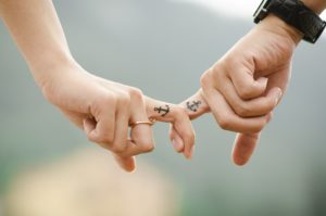 couple-hands-interlocking-fingers-with-matching-anchor-tattoos